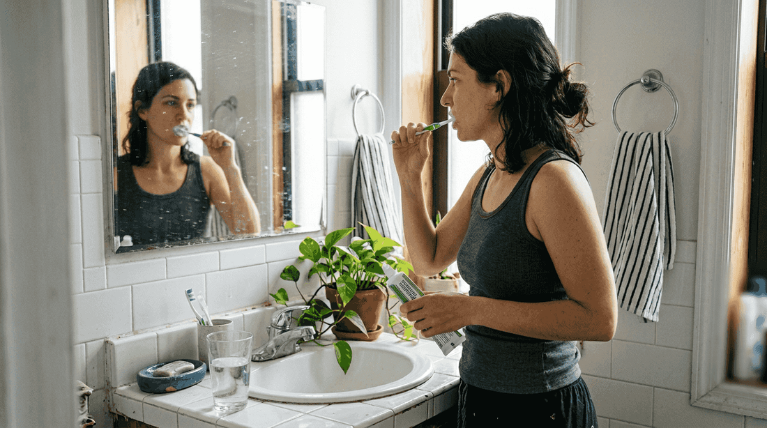 Woman brushing teeth with botanical toothpaste