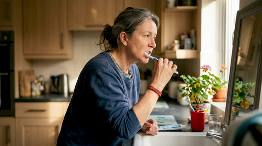 Woman brushing teeth in home bathroom