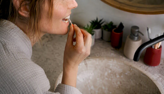 Hands using interdental brush for dental care