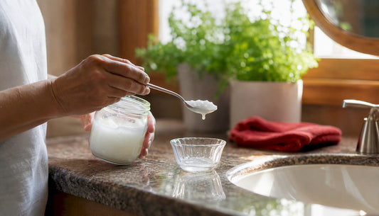 Hand holding spoon with coconut oil for pulling