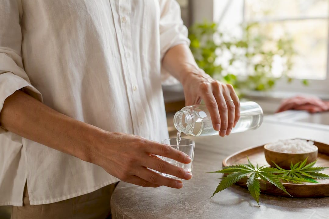 Hand pouring mouthwash into glass