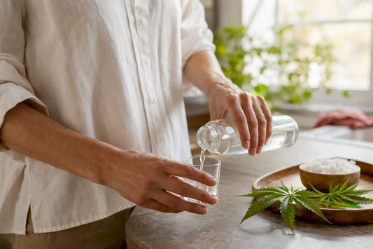 Hand pouring mouthwash into glass