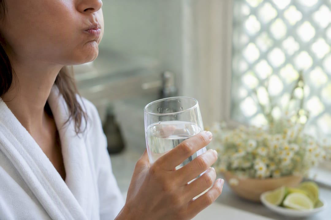 Person rinsing mouth with water