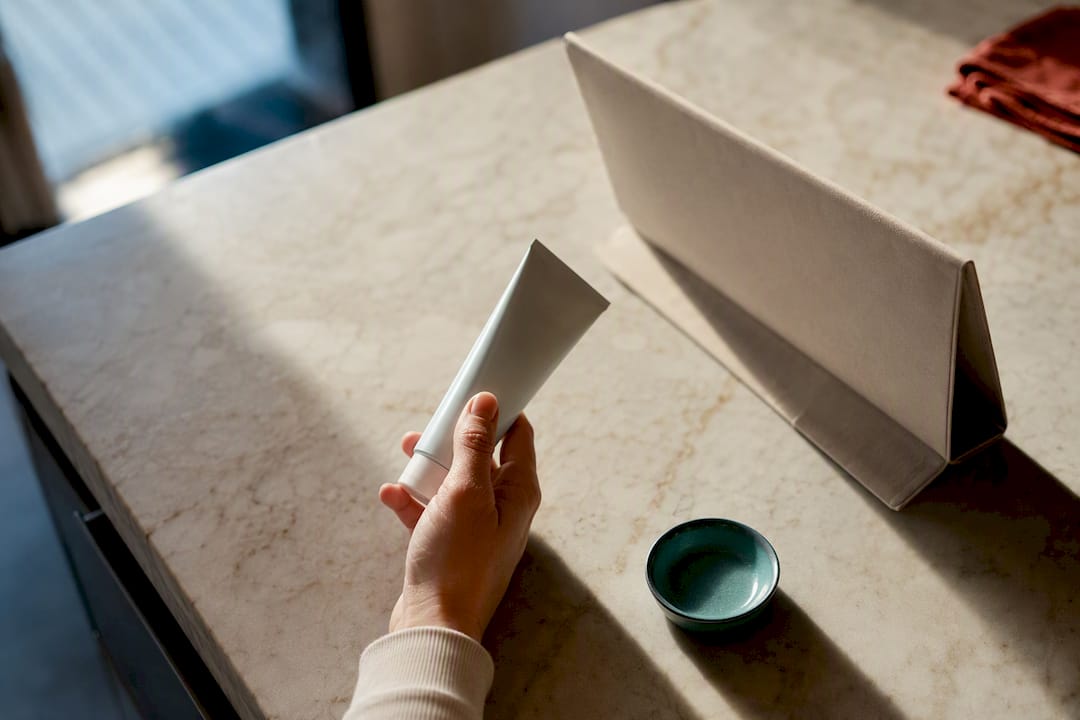 Hand examining anonymous toothpaste tube