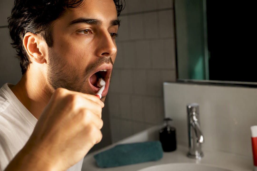 Toothbrush applying toothpaste to back teeth