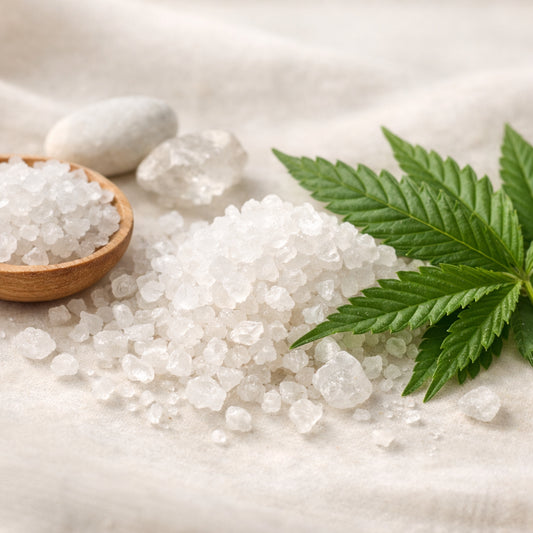 A realistic close‑up of natural minerals like Dead Sea salt crystals and hemp leaves on a soft background, showing texture and purity. Alt: natural mineral ingredients for oral care