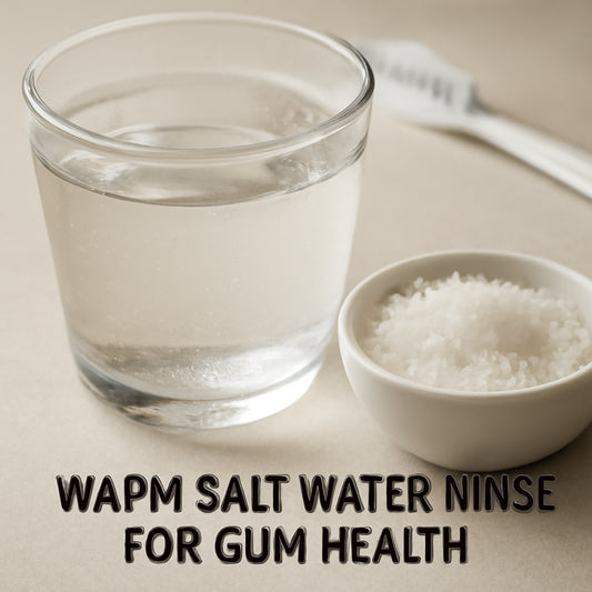 A close‑up of a warm glass of salt water next to a cup of sea salt, with a subtle dental brush in the background. Alt: Warm salt water rinse for gum health