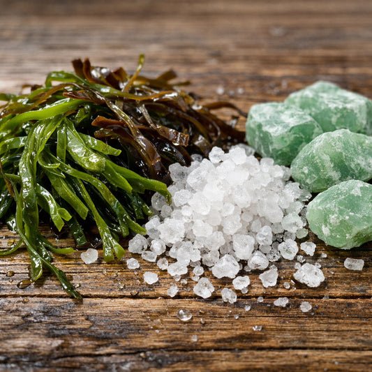 A realistic close‑up of seaweed strands and mineral crystals on a wooden surface, alt: marine algae toothpaste ingredients for oral care