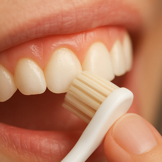 A close‑up of a hand gently brushing gums with a soft‑bristle toothbrush, soft natural lighting, showing healthy pink gum tissue next to a tooth. Alt: Identify common causes of gumbleeding with gentle brushing technique.